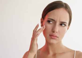 femme touche visage peau