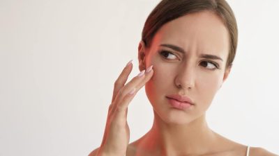 femme touche visage peau